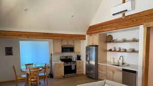 Une cuisine moderne avec des meubles en bois, un réfrigérateur en acier inoxydable et un four à micro-ondes encastré.