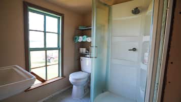 Een douche, handdoeken, zeep, toiletpapier