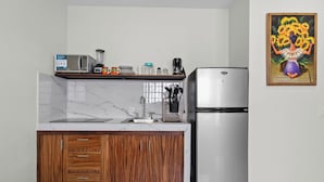 Een moderne keuken met een marmeren aanrecht, houten keukenkastjes, een roestvrijstalen koelkast en een magnetron.