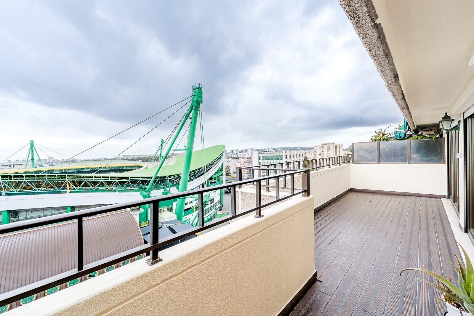 Ein Balkon mit Blick auf ein grünes Stadion und Stadtgebäude.