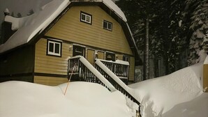A snow-covered house with a staircase leading to the entrance. - Walk to Village - 2 Bdrm, +Loft, 2 Bath - Mammoth Haus (Mammoth Lakes)