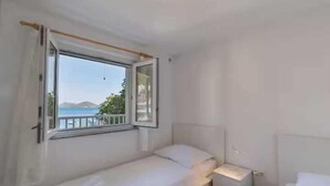 A small, single-bed room with a window overlooking a scenic view. - Apartment Spajic by aneo travel (Klek)