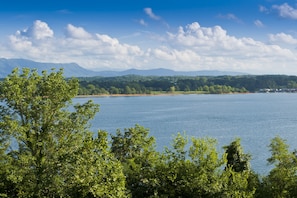 A lake with a forested shoreline and distant mountains. - New Era Peak by Jackson Mountain Rentals (Sevierville)