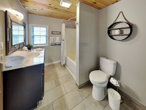 A bathroom with a sink, mirror, toilet, and shower. - New Era Peak by Jackson Mountain Rentals (Sevierville)