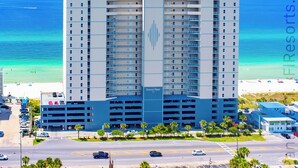 Un hotel moderno de gran altura con varios pisos, una estructura vertical prominente y un garaje.