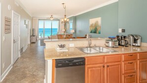 Una cocina con encimeras de granito, electrodomésticos de acero inoxidable y armarios de madera.