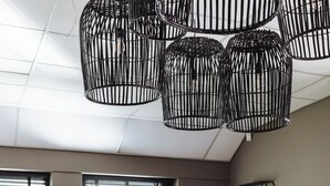 Un salón de conferencias con una mesa larga, sillas e lámparas colgantes de metal negro.