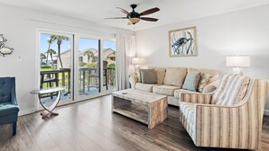 A living room with a sofa, armchair, coffee table, and a ceiling fan. - Blue Surf 5 (Miramar Beach)