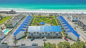 A hotel with a central courtyard, a swimming pool, and a view of the beach. - Blue Surf 5 (Miramar Beach)