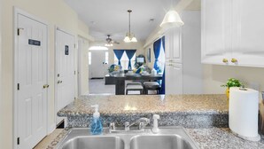A modern kitchen with granite countertops, stainless steel sinks, and pendant lighting. - Minutes from Cherry Point (Havelock)