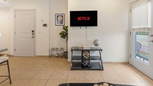 Una sala de estar con un televisor instalado en la pared mostrando 