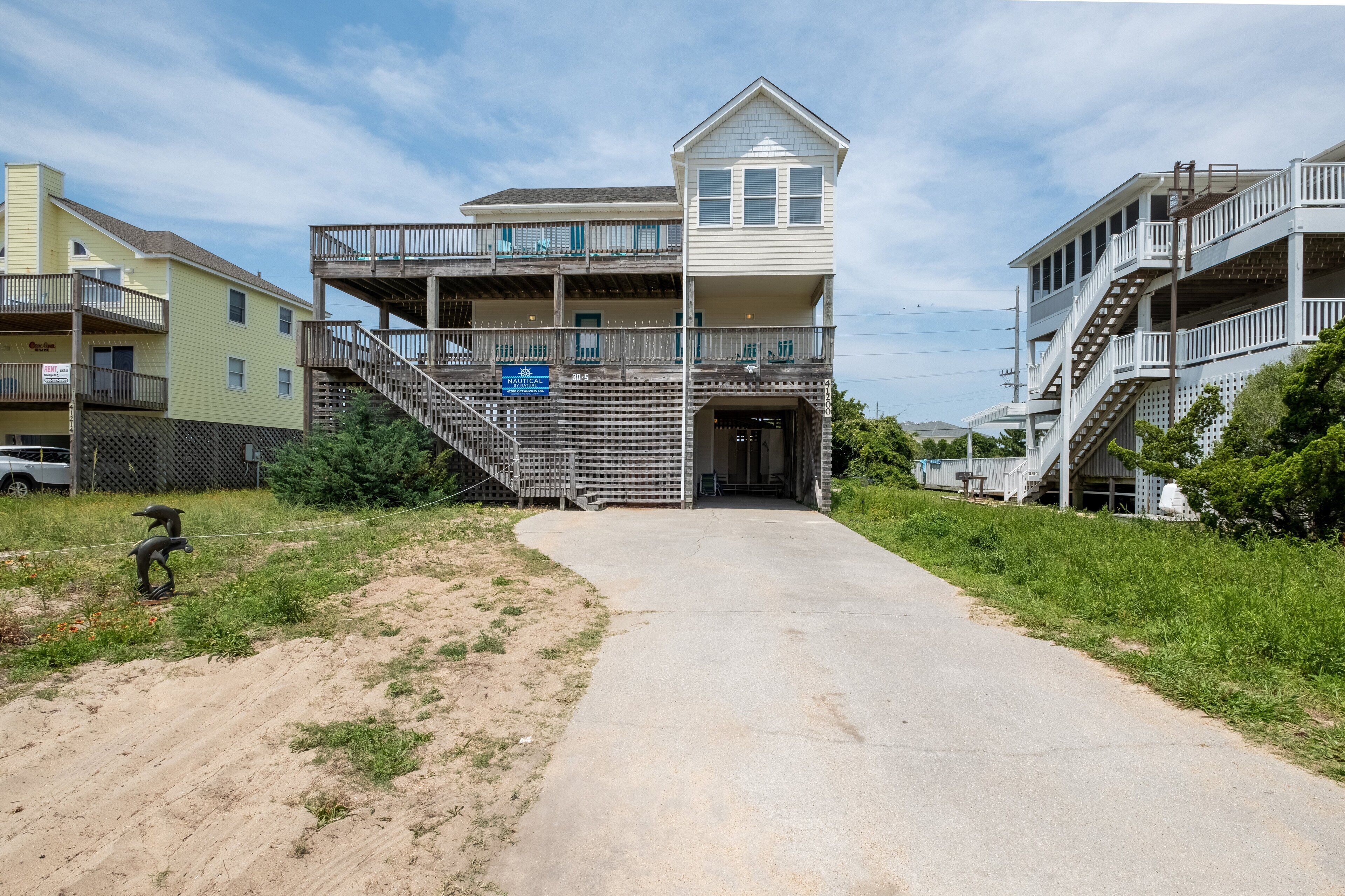 A beachfront property with a central building featuring a balcony and a staircase leading to an upper level.