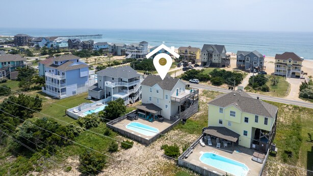 Zona residencial costera con casas, una playa y un muelle.