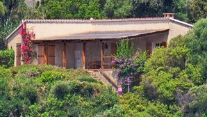 Un bâtiment de style rustique, doté d’un toit plat, de portes en bois et d’un porche abrité.