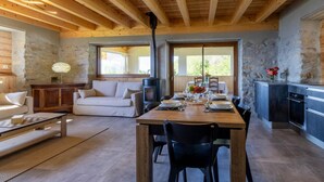 A cozy interior with a dining area, a sofa, and a fireplace.