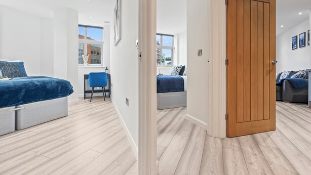 Un dormitorio moderno con una cama, un escritorio y una silla.