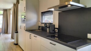 A modern kitchen with a stainless steel range hood, a built-in oven, and a black countertop. - 2 bedroom lovely home in Hellendoorn (Hellendoorn)