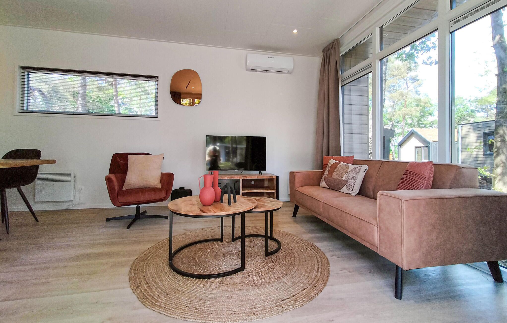 A modern living room with a sofa, armchair, TV, and a small coffee table.