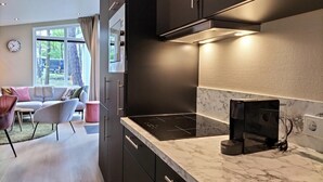A modern kitchen with dark cabinets, a black stove, and a marble countertop. - Awesome home in Hellendoorn with WiFi (Hellendoorn)