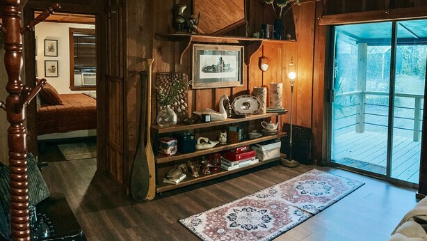 Ein gemütliches Zimmer mit Holzböden, einem großen Fenster und einer Holztreppe.