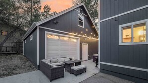 Ein modernes Haus mit überdachter Terrasse, Garage und Lichterketten.