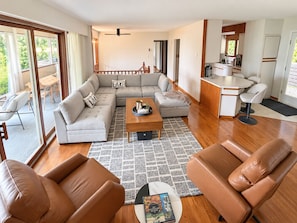 Una sala de estar moderna con un sofá seccional, una mesa de centro y sillones de cuero.