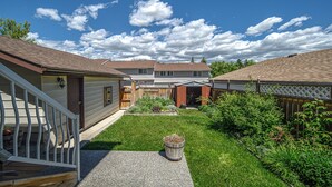 A residential area with multiple houses, a well-maintained lawn, and a wooden fence. - Spacious Home Near Stampede & Downtown Fully Fenced Yard Double Garage Pet OK (Calgary)