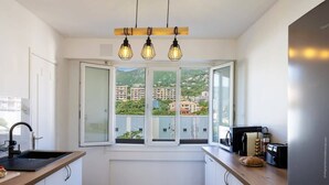 Una cocina moderna con un ventanal amplio, horno empotrado y una encimera con tostadora y un panera.