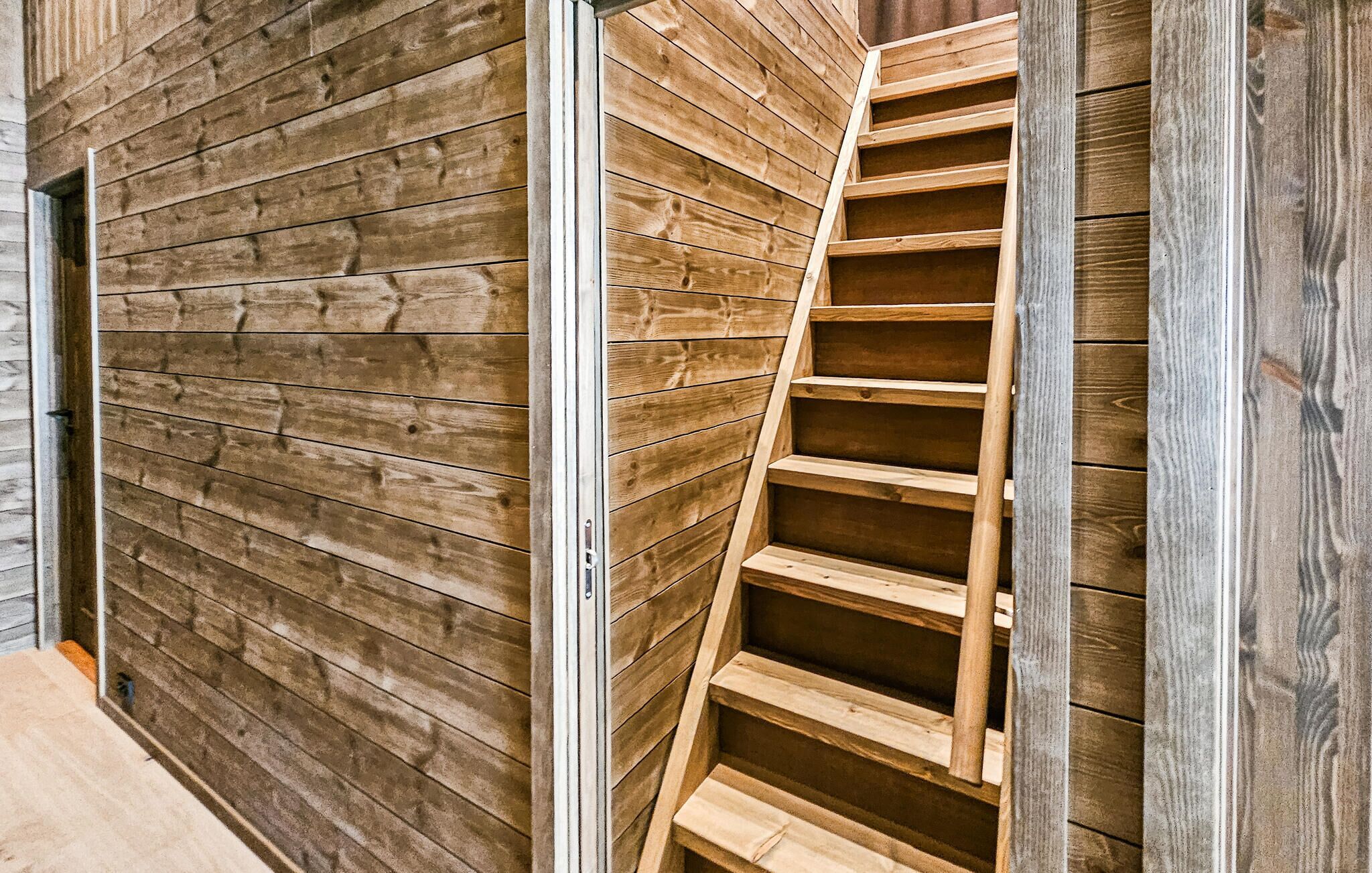 Un escalier en bois au design moderne, menant à un niveau supérieur.