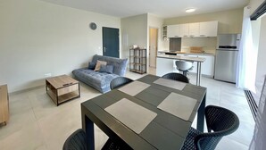 A modern apartment with a dining area, kitchen, and living space.