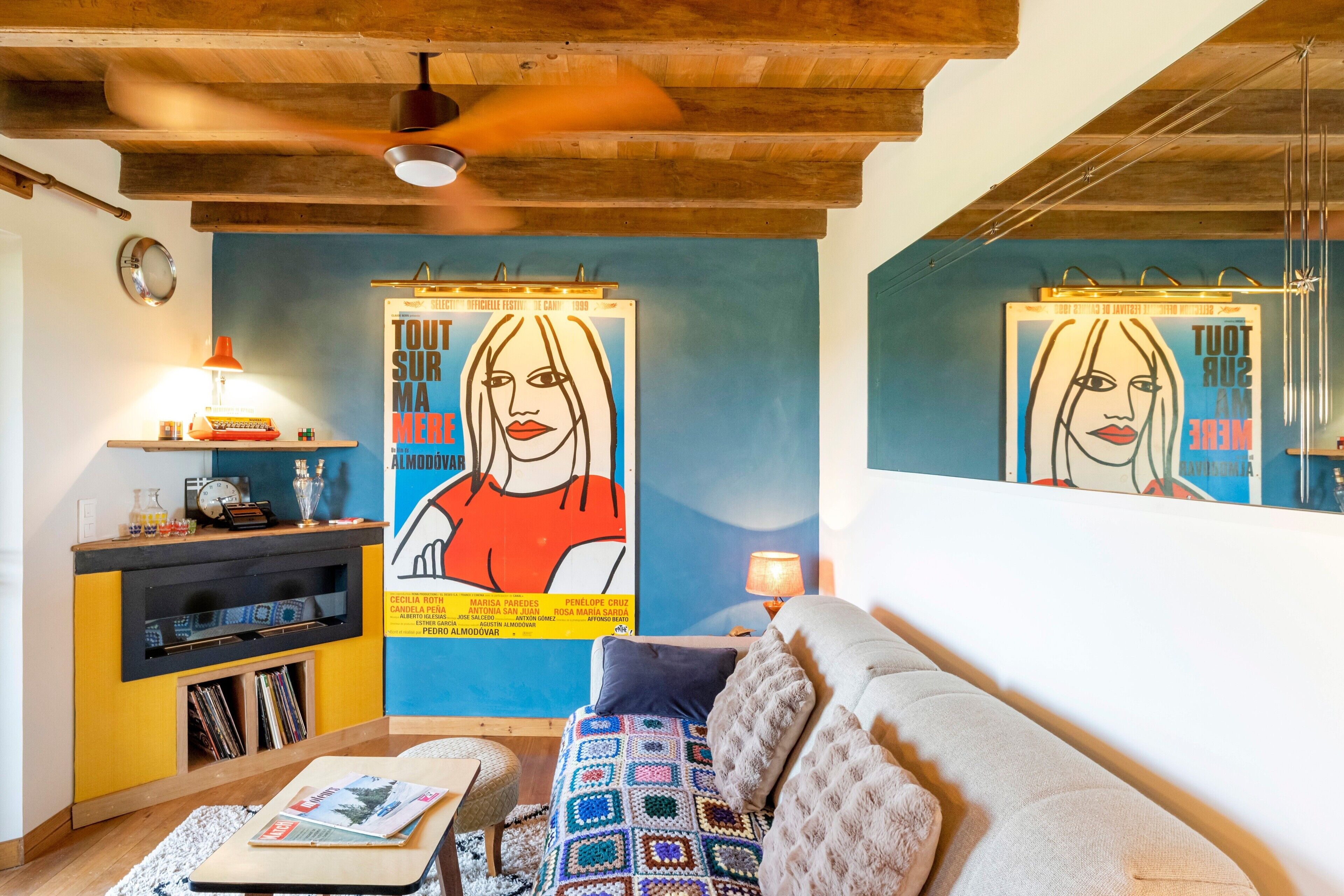 Una sala de estar con una pared azul, un sofá, una mesita de centro y una estantería.