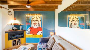 Una sala de estar con una pared azul, un sofá, una mesita de centro y una estantería.