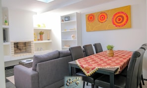 Un espace repas comprenant une table, des chaises et un tableau décoratif.