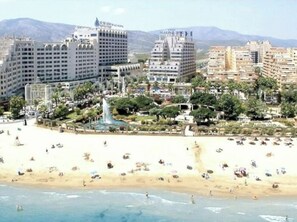 A coastal cityscape with a beach, hotels, and a fountain. - Marina Dor Torremar (Oropesa del Mar)