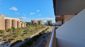 A view of a residential area with multi-story buildings, a road, and a clear sky.