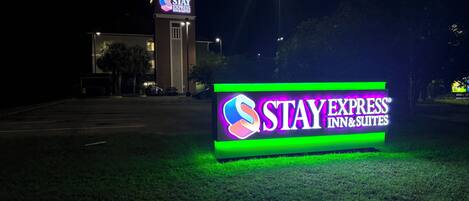 A Stay Express Inn & Suites sign illuminated at night.