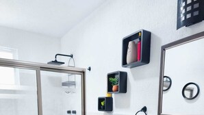 A modern bathroom with a glass shower enclosure, a white sink, and a mirror above the vanity. - Sunrise in Cancun. all pets are welcome. (Cancún)