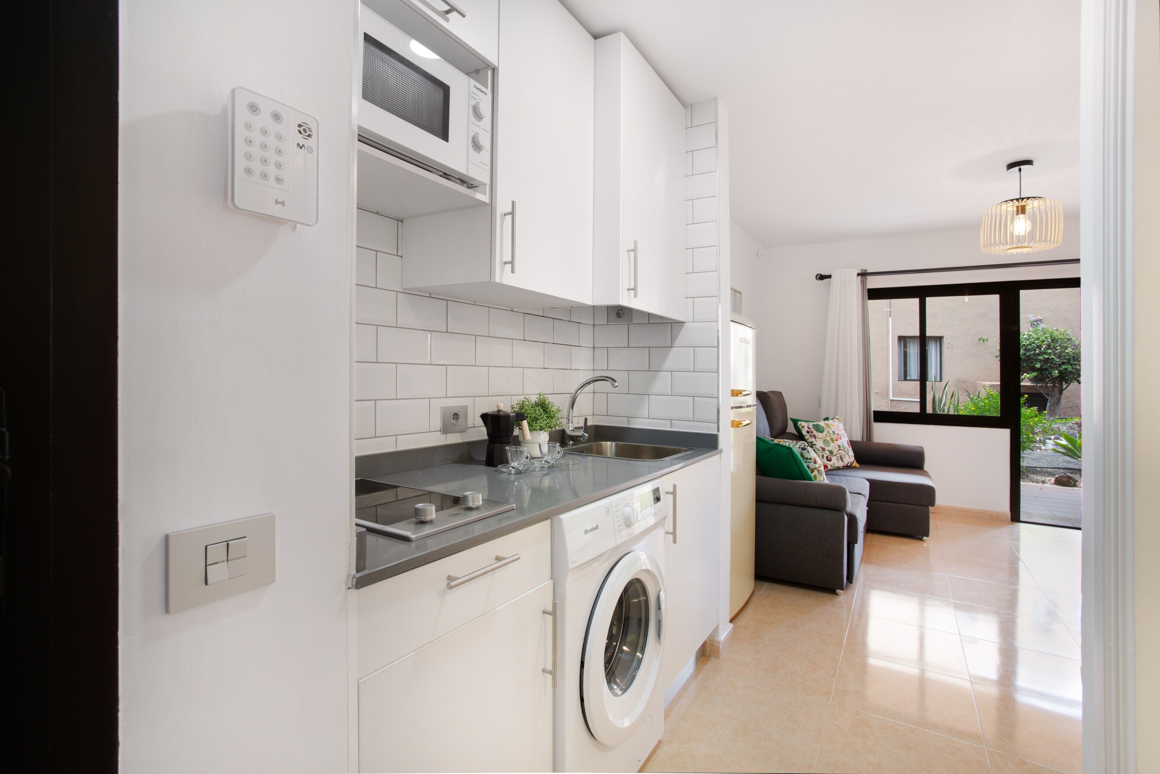 Een moderne keuken met een ingebouwde wasmachine, een magnetron en een spoelbak.