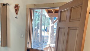 A wooden door with a glass panel, a wooden wall-mounted hook, and a wooden floor. - Pet friendly cabin in the woods perfect for your adventures (Big Bear)