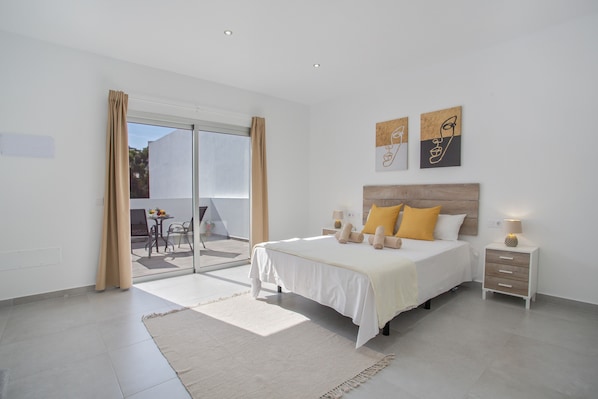 A bedroom with a bed, bedside tables, and artwork on the wall.