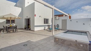 A modern outdoor patio with a pool, a dining area, and a covered seating area. - Holiday Home 'Gara Fuerteventura' with Pool, Wi-Fi and Air Conditioning (Gran tarajal)