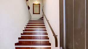 A staircase with wooden steps and a metal handrail, leading to a door with a round doorknob.