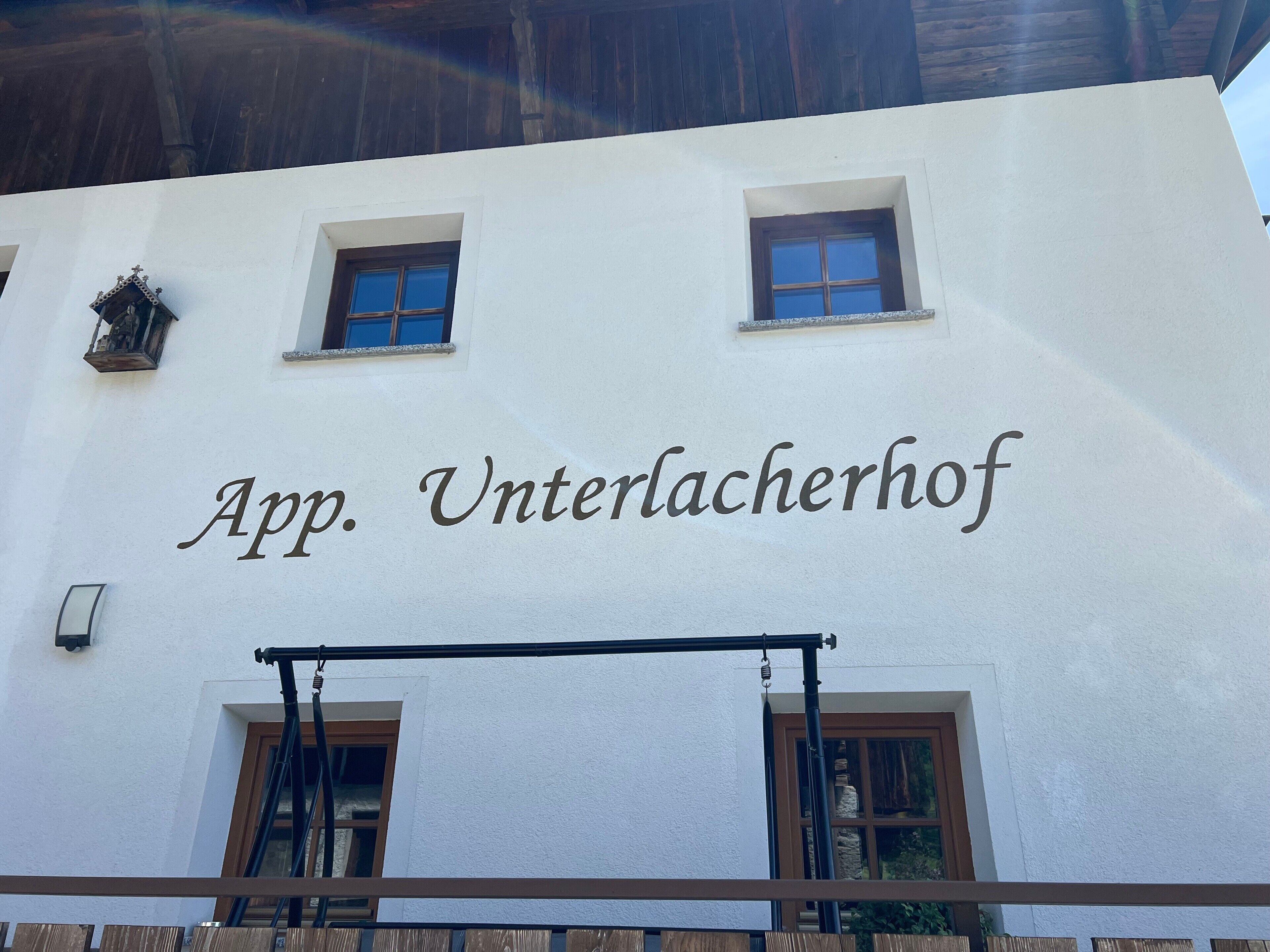 Un edificio con el letrero 'App. Unterlacherhof', que indica un hotel u otro establecimiento similar.