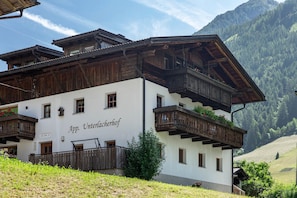 A traditional wooden building with balconies and a sign reading 'App. Unteracherhof.'