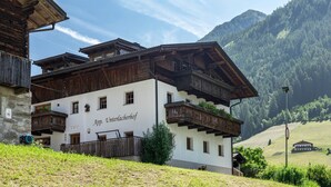 Un edificio de madera tradicional con balcones, un letrero que dice 'App. Interlacherhof' y un paisaje montañoso al fondo.