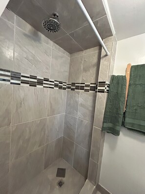 Een douche, handdoeken, zeep, shampoo