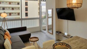 A modern living room with a sofa, a dining table, and two hanging wicker lamps. - Playa de la Fontanilla Marbella (Marbella)