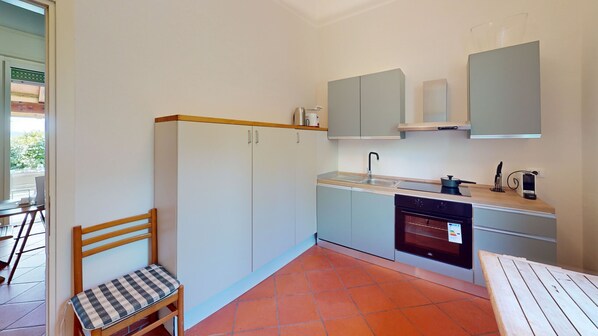 Una cocina compacta con pileta, estufa y alacenas.