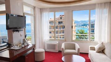 Suite familiar, 1 cama de matrimonio grande con sofá cama, balcón, vistas al mar | Zona de estar | Televisión de 32 pulgadas con canales por satélite