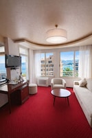 Suite familiar, 1 cama de matrimonio grande con sofá cama, balcón, vistas al mar | Zona de estar | Televisión de 32 pulgadas con canales por satélite